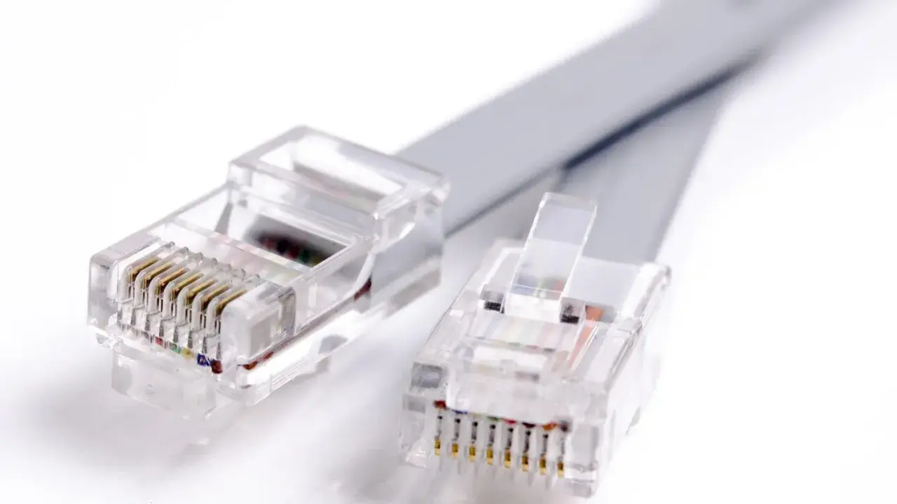 Deux connecteurs de prise téléphone transparents avec des fils colorés, prêts à établir une connexion.