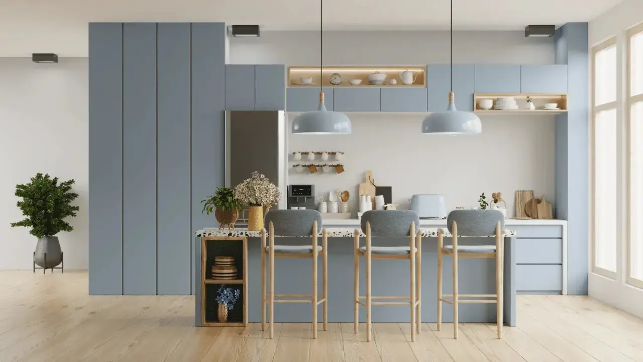 Cuisine moderne aux meubles bleus doux, avec un îlot central et des tabourets. L'éclairage doux crée une ambiance couleur blanc chaud.