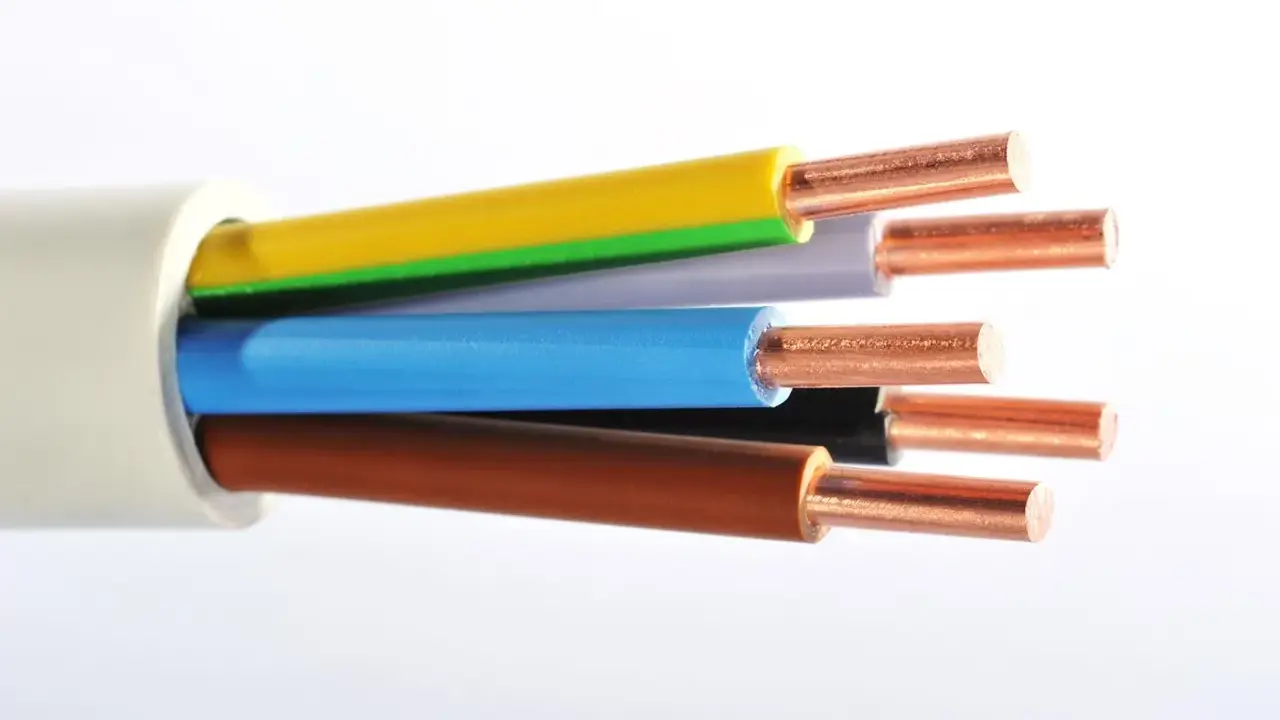 Gros plan sur un type de câble électrique avec des fils de cuivre dénudés de différentes couleurs : jaune, vert, gris, bleu, noir et marron.