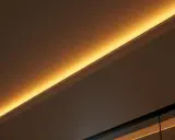 Éclairage indirect chaleureux, comme si on venait de brancher ruban led sur interrupteur pour créer une ambiance douce.