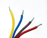 Quatre fils électriques dénudés : jaune, fil bleu électrique, marron et rouge, sur fond blanc.
