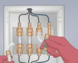 Main électrique avec fusibles. Une main gantée insère un fusible, illustrant le branchement d'un ampèremètre.