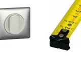 Interrupteur Legrand en métal brossé et mètre ruban jaune. Mesure de la hauteur interrupteur.