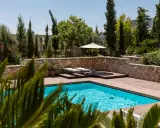 Piscine luxueuse avec terrasse en bois, transats, parasol et bouée. La protection électrique de la piscine est assurée pour une baignade en toute sécurité.