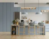 Cuisine moderne aux meubles bleus doux, avec un îlot central et des tabourets. L'éclairage doux crée une ambiance couleur blanc chaud.