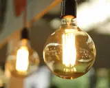 Plusieurs ampoules LED de différents types, avec un filament visible, diffusent une lumière chaude et dorée.