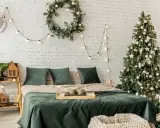 Décoration de chambre festive : comment accrocher guirlande lumineuse au mur, avec sapin, couronne et bois de cerf.
