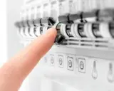 Doigt actionnant un disjoncteur dans un tableau électrique. Aide à comprendre quel disjoncteur différentiel choisir pour votre installation.