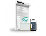 Un volet roulant blanc connecté, une box domotique Somfy et un smartphone affichant l'application. Idéal pour savoir quel volet roulant choisir.