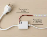 Comment brancher des LED sans prise : un adaptateur blanc relie un câble secteur à un ruban LED.