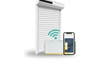 Un volet roulant blanc connecté, une box domotique Somfy et un smartphone affichant l'application. Idéal pour savoir quel volet roulant choisir.