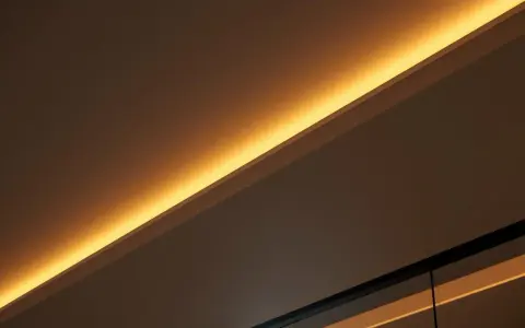 Éclairage indirect chaleureux, comme si on venait de brancher ruban led sur interrupteur pour créer une ambiance douce.