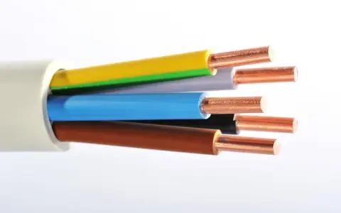Gros plan sur un type de câble électrique avec des fils de cuivre dénudés de différentes couleurs : jaune, vert, gris, bleu, noir et marron.