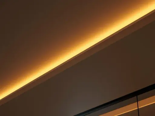 Éclairage indirect chaleureux, comme si on venait de brancher ruban led sur interrupteur pour créer une ambiance douce.