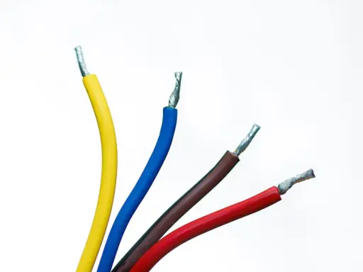Quatre fils électriques dénudés : jaune, fil bleu électrique, marron et rouge, sur fond blanc.