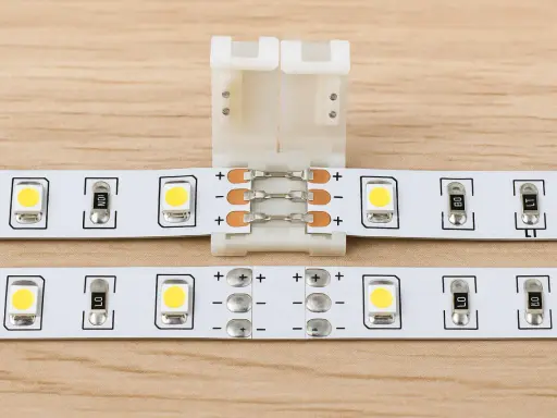 Connecteur pour montrer comment brancher plusieurs LED ensemble. Des bandes LED blanches avec des composants électroniques sont visibles.
