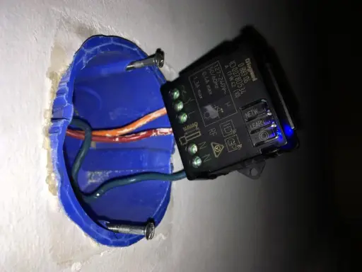 Schéma branchement interrupteur sans fil : module RF dans boîte d'encastrement bleue avec fils électriques.