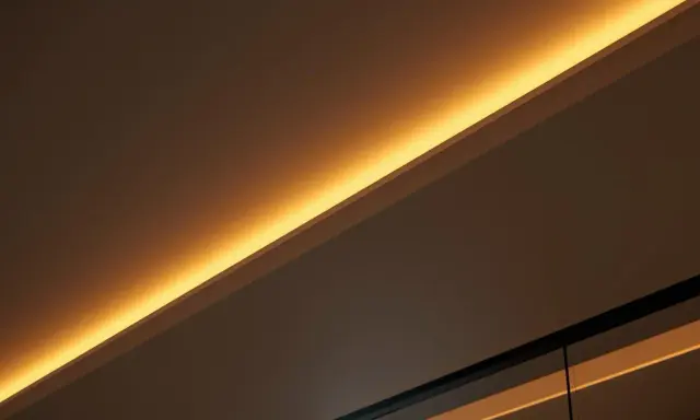 Éclairage indirect chaleureux, comme si on venait de brancher ruban led sur interrupteur pour créer une ambiance douce.