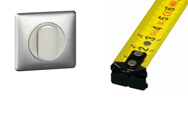 Interrupteur Legrand en métal brossé et mètre ruban jaune. Mesure de la hauteur interrupteur.