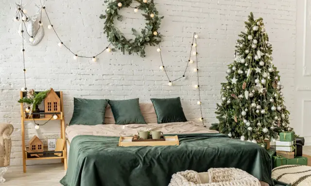 Décoration de chambre festive : comment accrocher guirlande lumineuse au mur, avec sapin, couronne et bois de cerf.