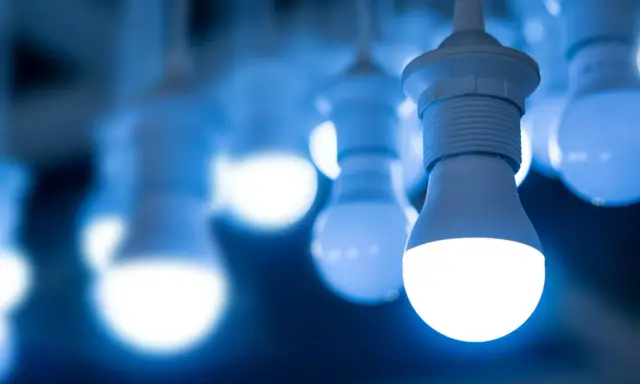 Plusieurs ampoules LED modernes, dont les 4 types d'ampoules, brillent d'une lumière bleue froide.