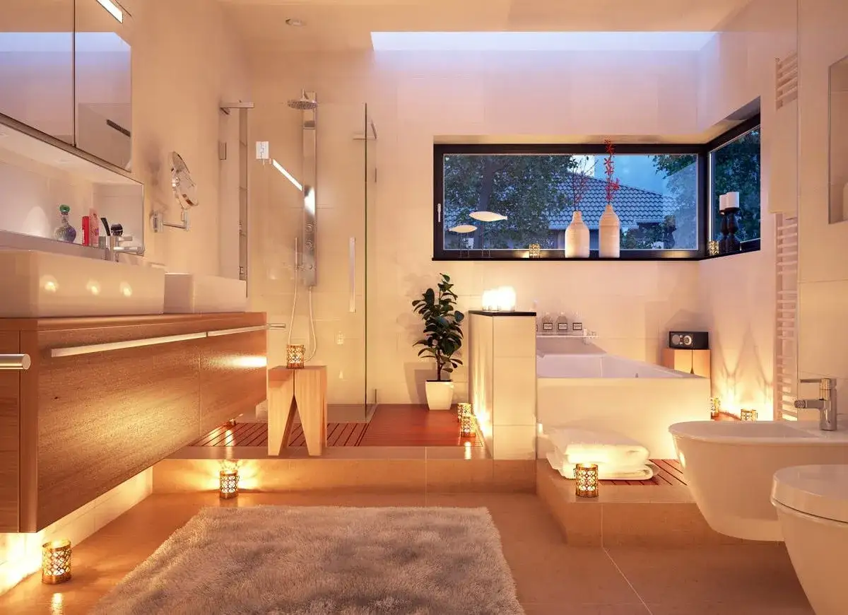 Salle de bain moderne avec baignoire, douche, double vasque et éclairage électrique doux créant une ambiance relaxante.