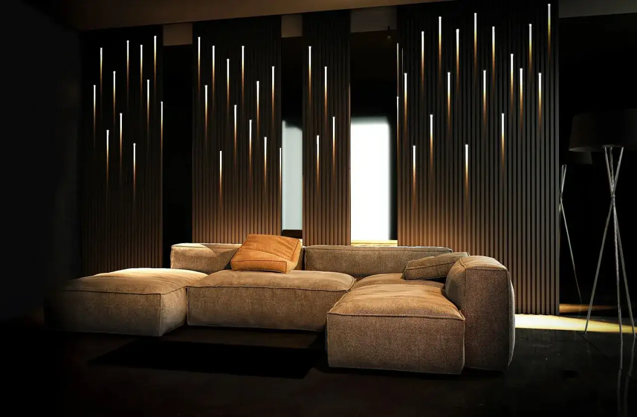 Un salon moderne avec un canapé confortable et un mur orné de fines lumières verticales, créant une ambiance chaleureuse grâce à une dalle led design.