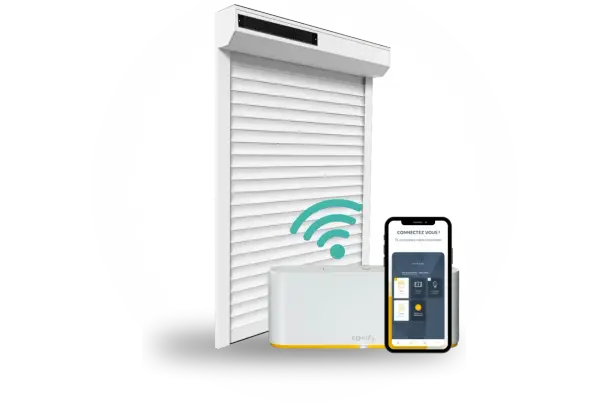 Un volet roulant blanc connecté, une box domotique Somfy et un smartphone affichant l'application. Idéal pour savoir quel volet roulant choisir.