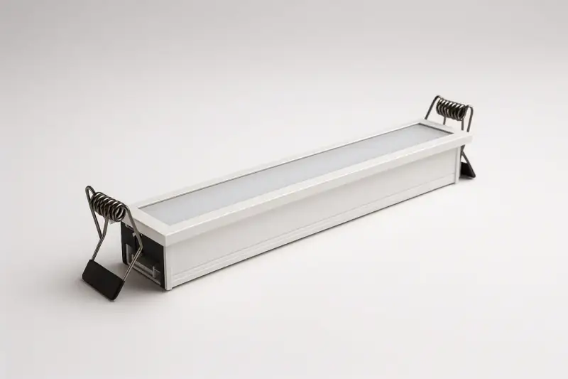 Une réglette led encastrable blanche avec des ressorts métalliques pour l'installation.
