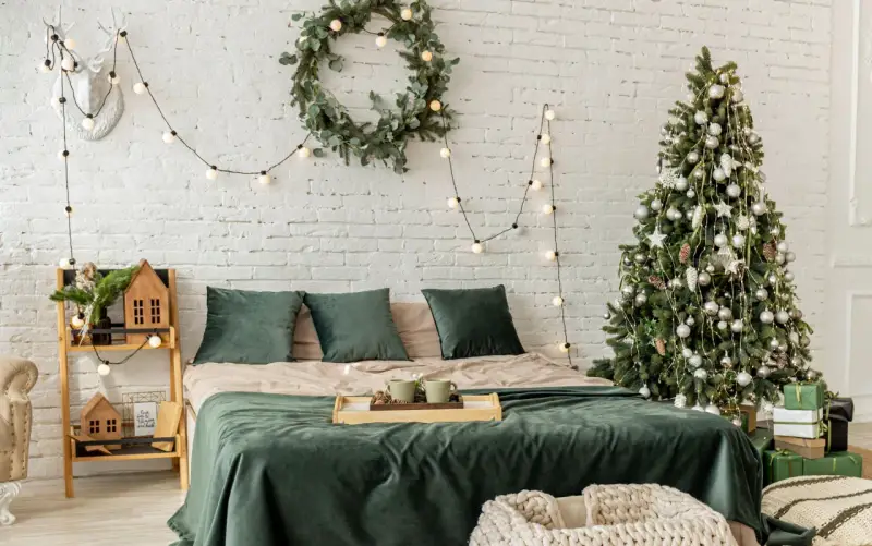 Décoration de chambre festive : comment accrocher guirlande lumineuse au mur, avec sapin, couronne et bois de cerf.